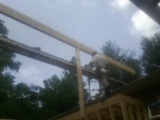 Carpenter setting a ridge beam over a new addition frame — Ice Dam Removal by Roofing Brothers in Lowellville