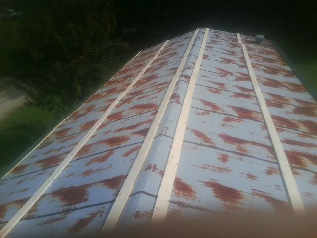 Rusted metal roof panels with new wood purlins before replacement — Storm Damage Roof Repair in Lowellville by Roofing Brothers
