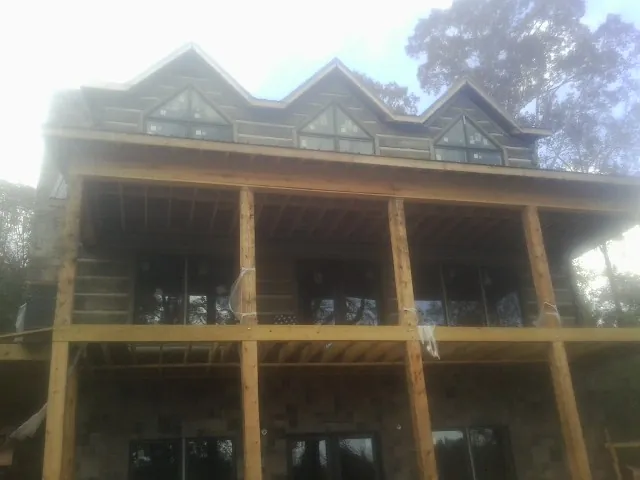 Dormers and porch framing on a large log home under construction — Roof Coating work by our crew in Lowellville
