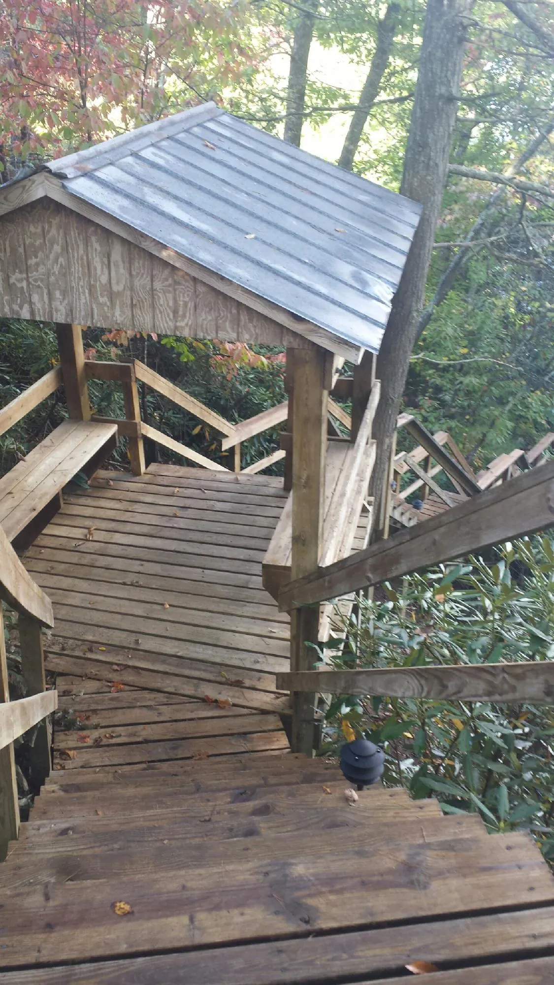 Metal roofed shelter over wooden steps on a wooded walkway — Skylight Repair & Installation work by our crew in Lowellville