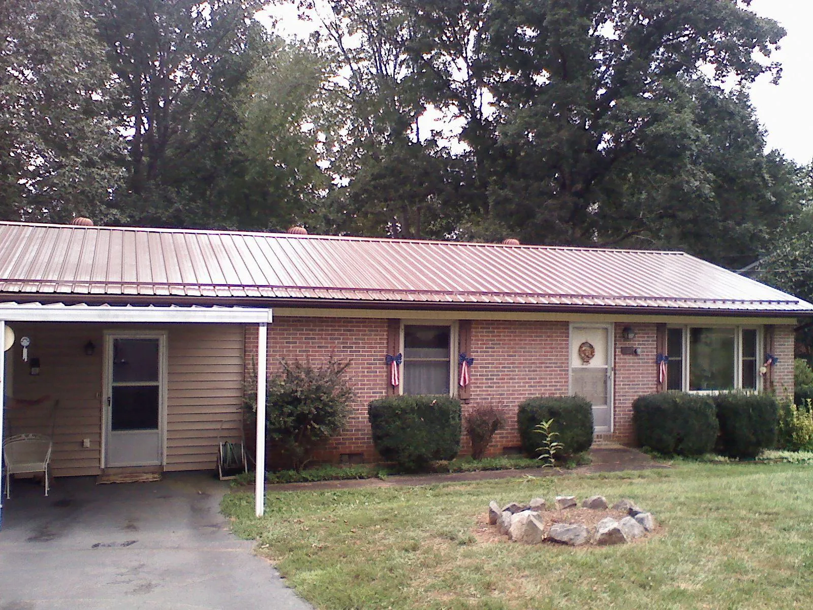 Bronze metal roof and carport on a brick ranch home — Roof Repair work by our crew in Lowellville